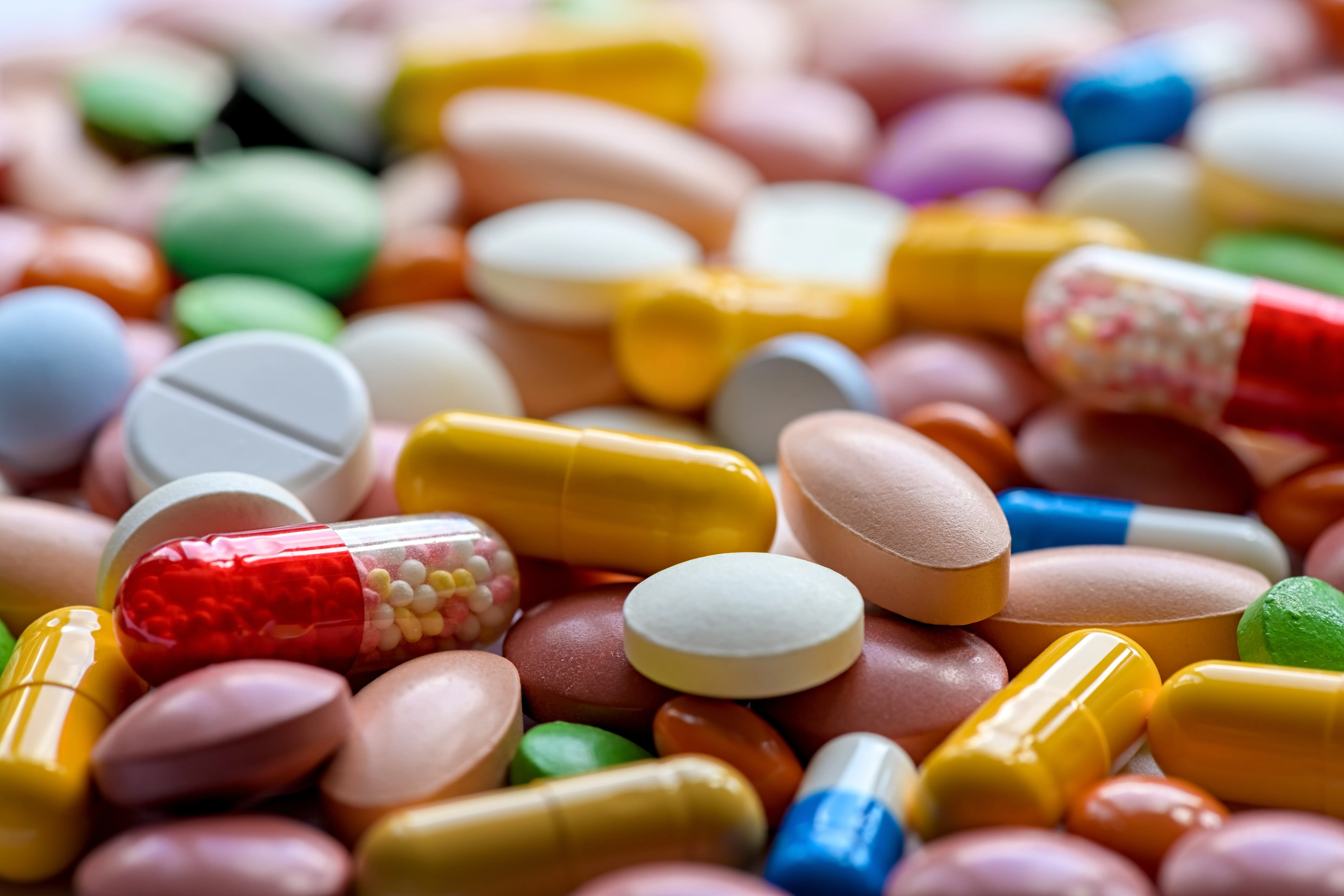Different colorful pills and drugs background. Medicinal tablets capsules pills. Selective focus